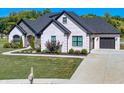 Beautiful home with stone and brick exterior, manicured lawn, black roof, and an attached two-car garage at 8112 Joni Ave, Martinsville, IN 46151