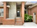 Close up of stone and brick front porch with stairs, black front door and meticulously maintained landscaping at 888 Westcreek Dr, Columbus, IN 47201