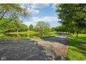 Scenic view of property featuring mature trees and a tranquil pond at 965 W Main St, Greenwood, IN 46142