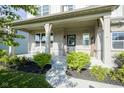 Inviting front porch with brick facade, tasteful landscaping, and a cozy seating area at 9822 Tampico Chase, Fishers, IN 46040