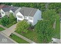 Aerial view of a two-story home with a well-kept lawn, complemented by mature trees and neighborhood views at 10316 Hatherley Way, Fishers, IN 46037