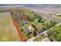 Expansive lot featuring open land, wooded area, and a cozy home, all enclosed by vibrant red property lines at 10473 N County Road 950 E, Brownsburg, IN 46112