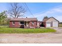 Charming single-story brick home with a detached garage and a welcoming front porch at 10473 N County Road 950 E, Brownsburg, IN 46112