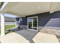 Covered back patio with sliding glass doors and stone accents, with recessed lighting at 1115 Senate Dr, Edinburgh, IN 46124