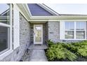 Elegant stone entryway with a glass front door and white framed windows and professionally landscaped at 1115 Senate Dr, Edinburgh, IN 46124