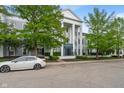 Charming condo building with mature trees, manicured bushes, and white car in the foreground at 12833 Tradd St # 1B, Carmel, IN 46032