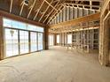 A spacious interior with large windows, wooden framing, and a vaulted ceiling, still under construction at 1415 Beaumont Cir, Westfield, IN 46074