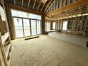 Large living room under construction with a high ceiling, big windows, and sliding doors to the exterior at 1415 Beaumont Cir, Westfield, IN 46074