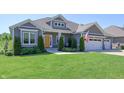 Inviting single-story home with landscaped yard and a cozy front porch seating area at 1472 Maple Ridge Ct, Columbus, IN 47201
