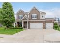 Charming two-story home featuring a brick facade, three-car garage, manicured lawn, and lush landscaping at 15143 Gallop Ln, Fishers, IN 46040