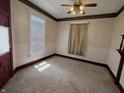 Vintage bedroom features a ceiling fan, carpeted floor, and natural light from a window, blending classic charm at 152 1St W St, Shelbyville, IN 46176
