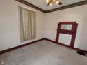 Bedroom features a vintage fireplace mantel and light from a window, blending classic charm with comfortable living at 152 1St W St, Shelbyville, IN 46176
