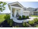 Inviting covered front porch with seating and manicured landscaping at 15413 Staffordshire Way, Fishers, IN 46037
