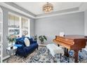 Bright living room with plush blue sofa, decorative pillows, wood floors and a modern chandelier, perfect for relaxation at 16516 Wilsons Farm Dr, Fishers, IN 46040