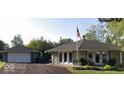 Charming home featuring a stone facade, flag pole, and a detached two car garage at 169 Bayview Dr, Cicero, IN 46034