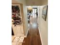 Hallway view with hardwood floors leading to the open living room with a fireplace at 209 Brighton Ct, Greenwood, IN 46143