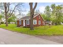 Brick house with green grass, showcasing a simple design with updated windows at 2321 W 26Th St, Anderson, IN 46016