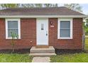 Inviting front entrance with a classic white door, brick facade, and landscaped details at 2321 W 26Th St, Anderson, IN 46016