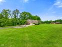 Scenic view of a charming brick home set amidst a lush green landscape and mature trees at 2508 Indian Creek Rd, Trafalgar, IN 46181