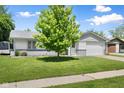 Quaint single-story home with an attached garage and a lush green lawn under a bright blue sky at 3022 Cameron St, Indianapolis, IN 46203