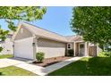Beautiful home featuring vinyl siding, a well-kept lawn, and an attached garage at 4033 Tahoe Dr, Indianapolis, IN 46235
