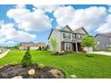 Attractive two-story home boasts lush lawn, mature trees, manicured landscaping, and an attached three-car garage at 4204 Omaha Dr, Bargersville, IN 46106