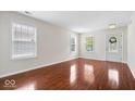 Bright and airy living room with gleaming hardwood floors, large windows, and a welcoming atmosphere at 4316 Village Trace Dr, Indianapolis, IN 46254