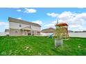 Spacious backyard with a playset and patio area, perfect for outdoor activities at 4763 W Tradwell Dr, New Palestine, IN 46163