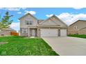 Charming two-story home featuring a well-manicured lawn, brick accents, and an attached two-car garage at 4763 W Tradwell Dr, New Palestine, IN 46163