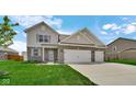 Charming two-story home with a two-car garage, landscaped lawn, brick and siding facade at 4763 W Tradwell Dr, New Palestine, IN 46163