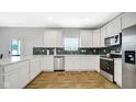 Modern kitchen featuring stainless steel appliances, white cabinets, and a beautiful backsplash at 4763 W Tradwell Dr, New Palestine, IN 46163