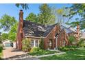 Charming brick home featuring manicured landscaping, a classic chimney, and a quaint, welcoming entrance at 5034 N Capitol Ave, Indianapolis, IN 46208
