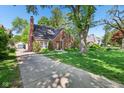 Charming brick home featuring manicured landscaping, a long driveway, and a quaint, welcoming entrance at 5034 N Capitol Ave, Indianapolis, IN 46208