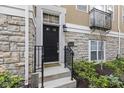 Home's welcoming entrance featuring a black door with decorative side panel and stone accents at 6665 Boxcar Pl, Indianapolis, IN 46220