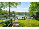 Lush backyard with a wooden walkway leading to a private dock on a serene lake at 7753 Ivy Dr, Nineveh, IN 46164