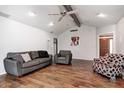 Cozy living room with hardwood floors, ceiling fan, neutral paint, and comfortable seating with sofa and chair at 7835 Quail S Rdg, Plainfield, IN 46168