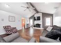 Relaxing living room area featuring hardwood floors, ceiling fan, cozy fireplace, and ample space for comfortable seating at 7835 Quail S Rdg, Plainfield, IN 46168