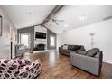 Spacious living room features hardwood floors, fireplace, ceiling fan, and abundant natural light from surrounding windows at 7835 Quail S Rdg, Plainfield, IN 46168