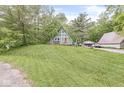 A-frame house on a large lot with a well-kept lawn, trees, and detached garage, creating a park-like setting at 809 Iron Bridge Rd, Cicero, IN 46034