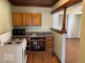 Functional kitchen with stove, microwave, cabinets, and an open layout connected to living areas at 909 Hickory St, Anderson, IN 46012