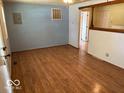 Spacious living room boasting wood-look flooring, natural light, and open access to other rooms at 909 Hickory St, Anderson, IN 46012