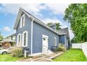 An angled exterior view showcases the home's design, including white trim, newer roof, and manicured yard at 1115 N Keystone Ave, Indianapolis, IN 46201