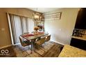 Dining room with a stone-top table, seating for six, modern chandelier, and a decorative rug at 11204 Sashing Way, Monrovia, IN 46157