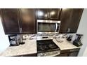 This is a kitchen with granite counters, stainless steel microwave, and dark cabinets at 11204 Sashing Way, Monrovia, IN 46157