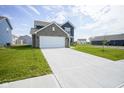 This new two-story home boasts an attached garage, a large driveway, and a freshly sodded lawn at 1181 Galaxy Ln, Danville, IN 46122