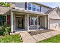 Inviting front porch with brick columns, red shutters, and landscaping with walkway leading to the main entrance at 1238 Aggie Ln, Indianapolis, IN 46260