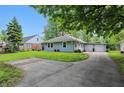 Exterior shot showcasing the house and long driveway leading to a detached two-car garage at 1245 Kessler Blvd E Dr, Indianapolis, IN 46220