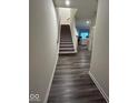 Hallway leads to staircase with carpeted steps and vinyl floors at 13460 Dewpoint Ln, Fishers, IN 46037