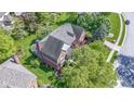 An aerial perspective of a brick house featuring a gray roof, lovely landscaping and surrounding greenery at 14215 Stacey St, Carmel, IN 46033