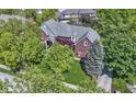 Overhead view of the brick home showcasing its manicured lawn, mature trees and architectural details at 14215 Stacey St, Carmel, IN 46033